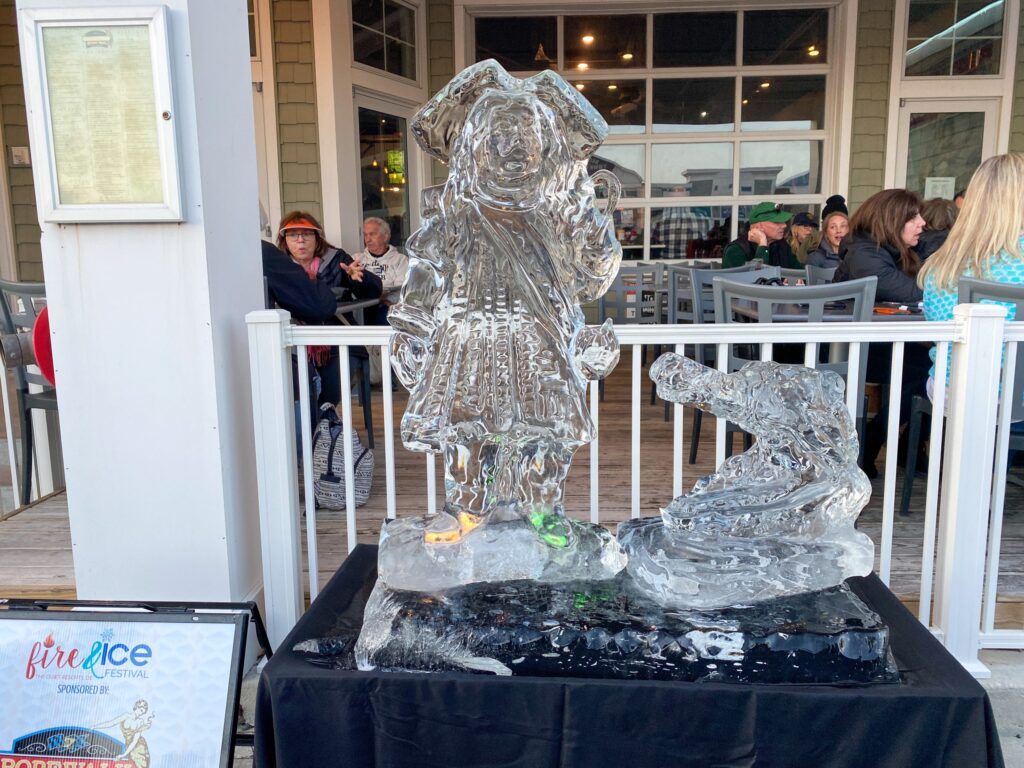 a glass statue of a man on a rock