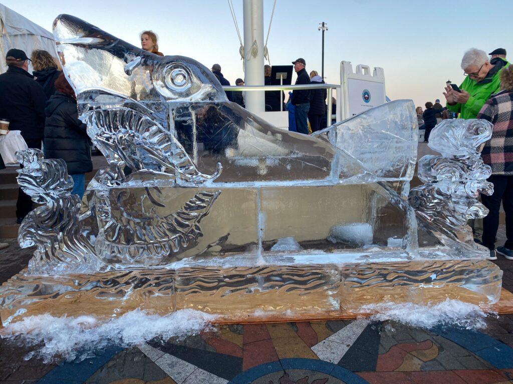 a group of people standing around an ice sculpture