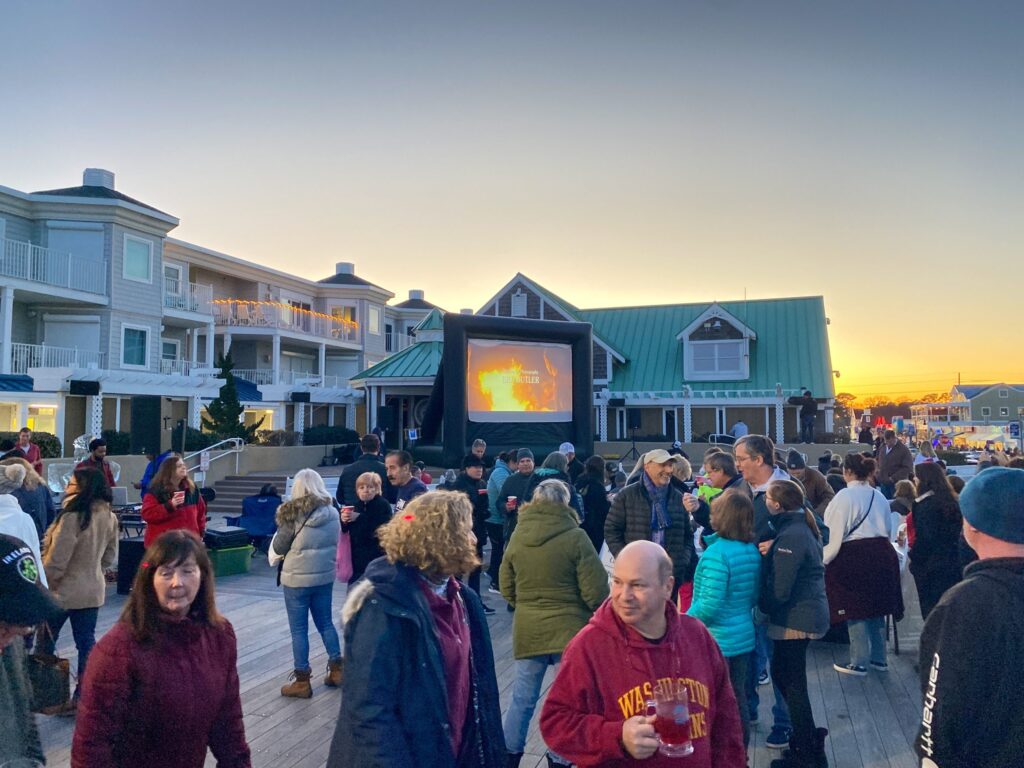 a crowd of people standing on top of a pier