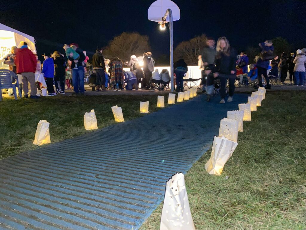 a group of people standing on top of a grass covered field