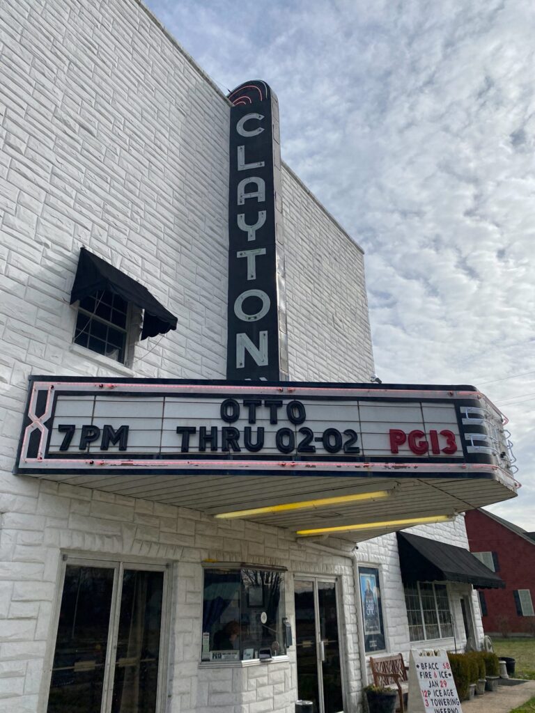 a white brick building with a marquee on the front of it