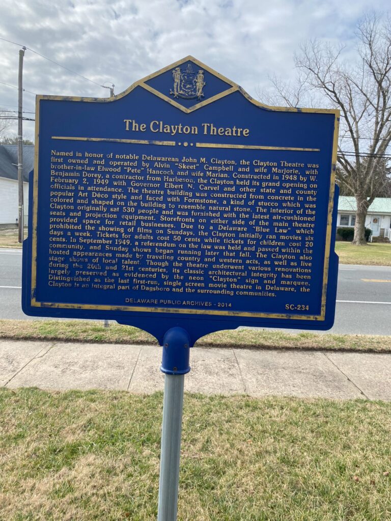a blue sign sitting on the side of a road
