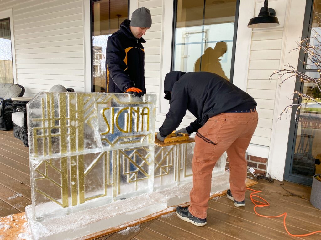 two men are working on a glass block