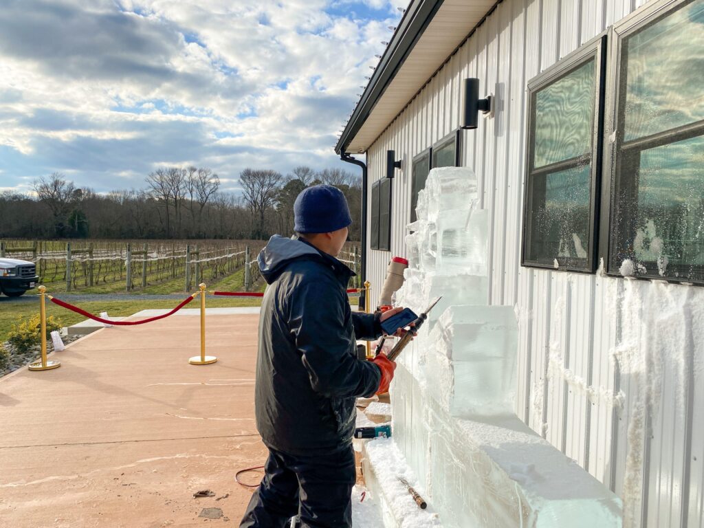 a man standing next to a building with ice on it