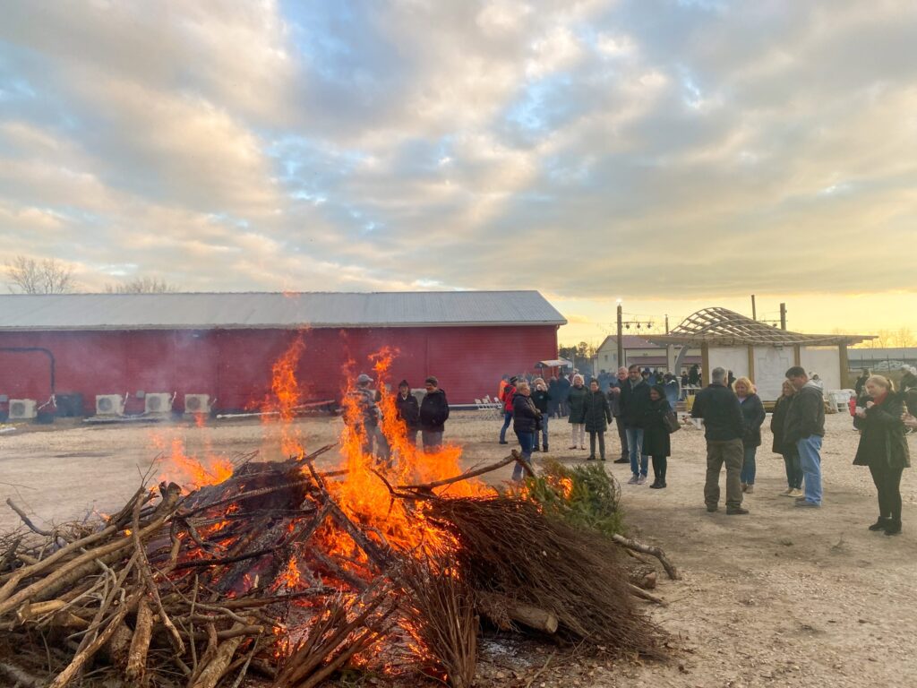 a group of people standing around a fire pit