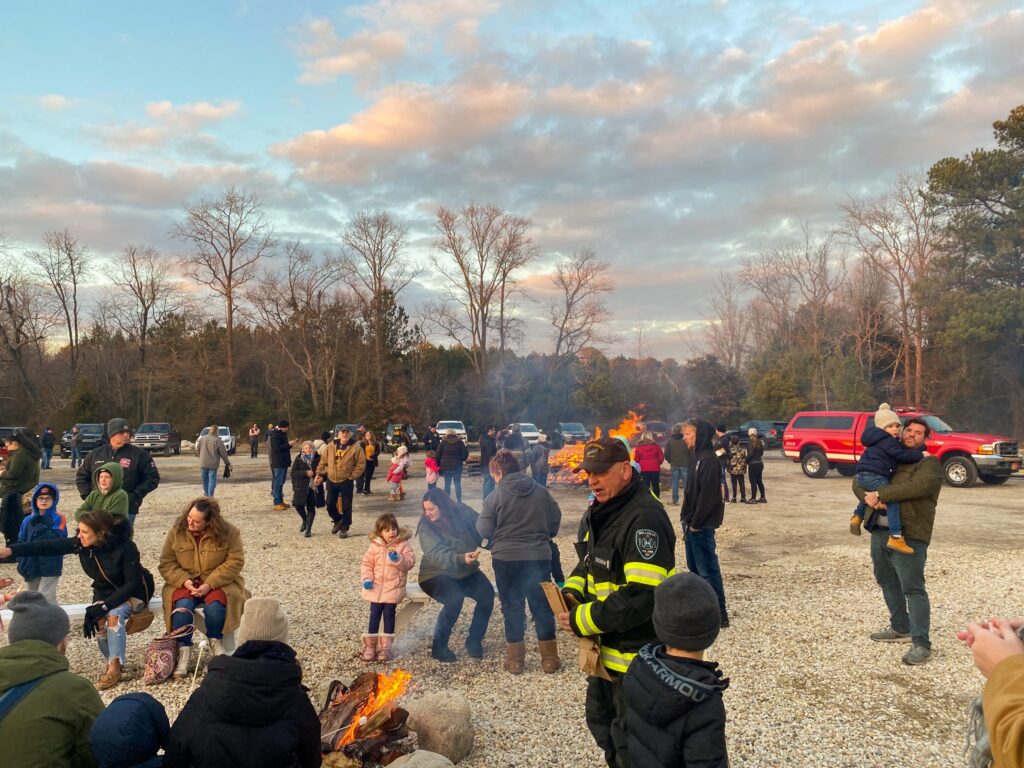 a group of people standing around a fire pit