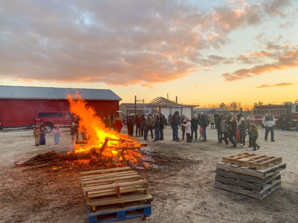 a group of people standing around a fire pit