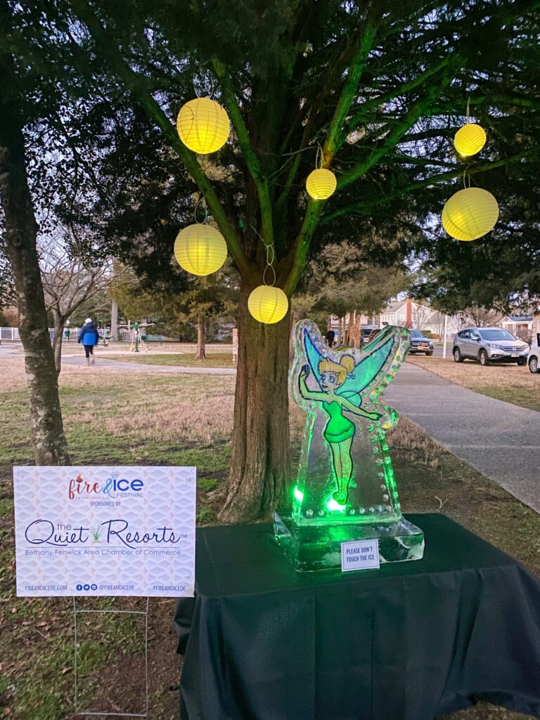 a table with a lit up fairy figurine next to a tree
