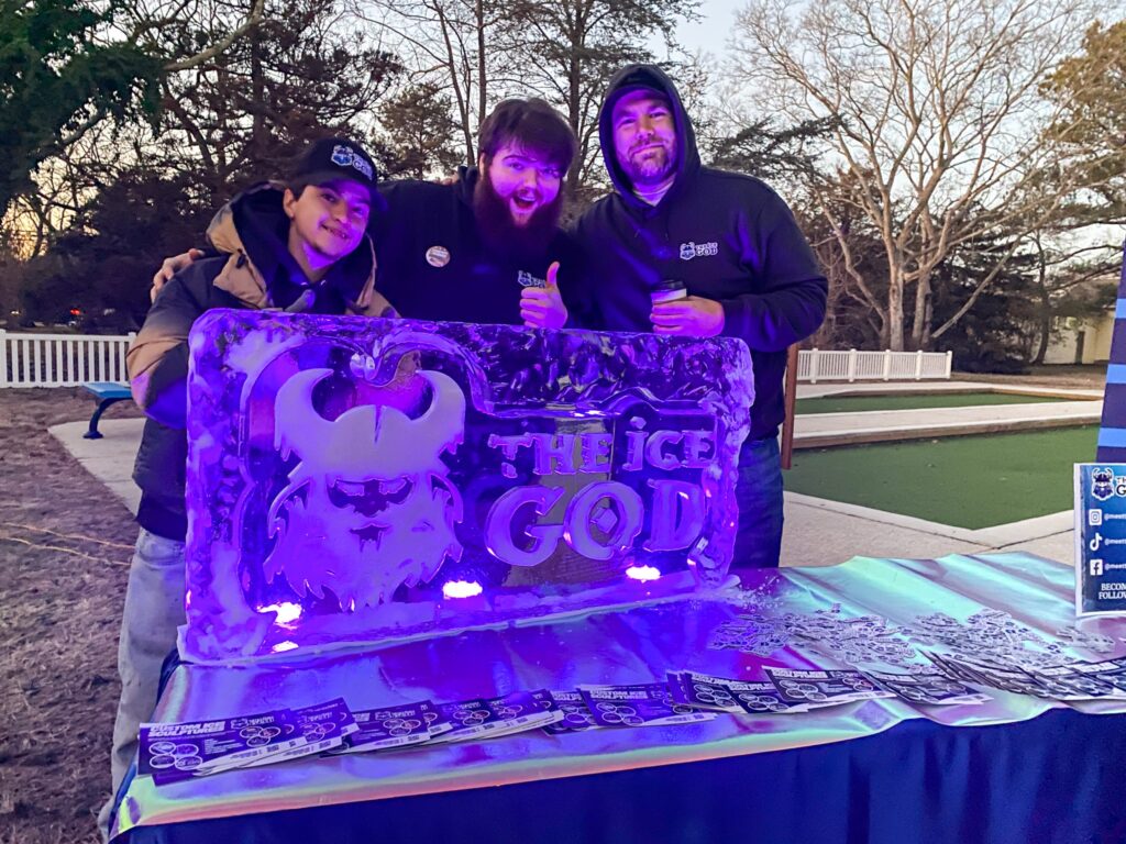 a group of people standing next to a purple sign