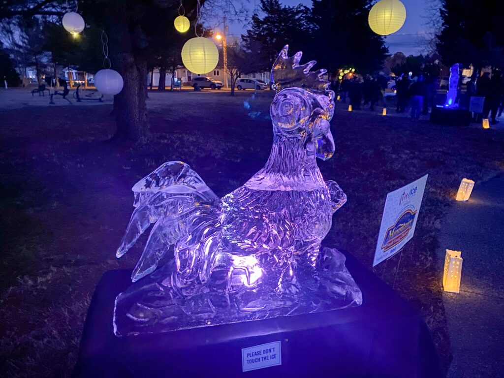 a lit up statue of a chicken on a table