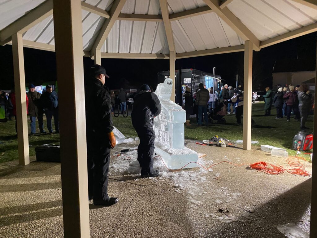 a group of people standing around an ice sculpture