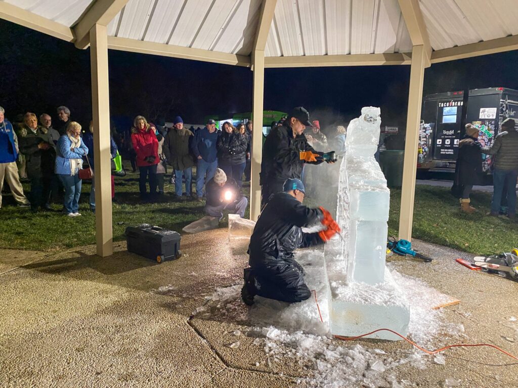 a group of people standing around a large ice sculpture