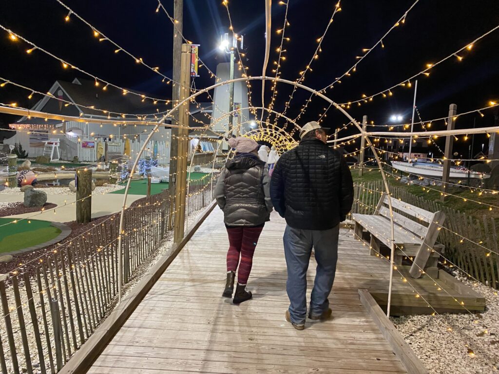 a man and a woman walking down a wooden walkway