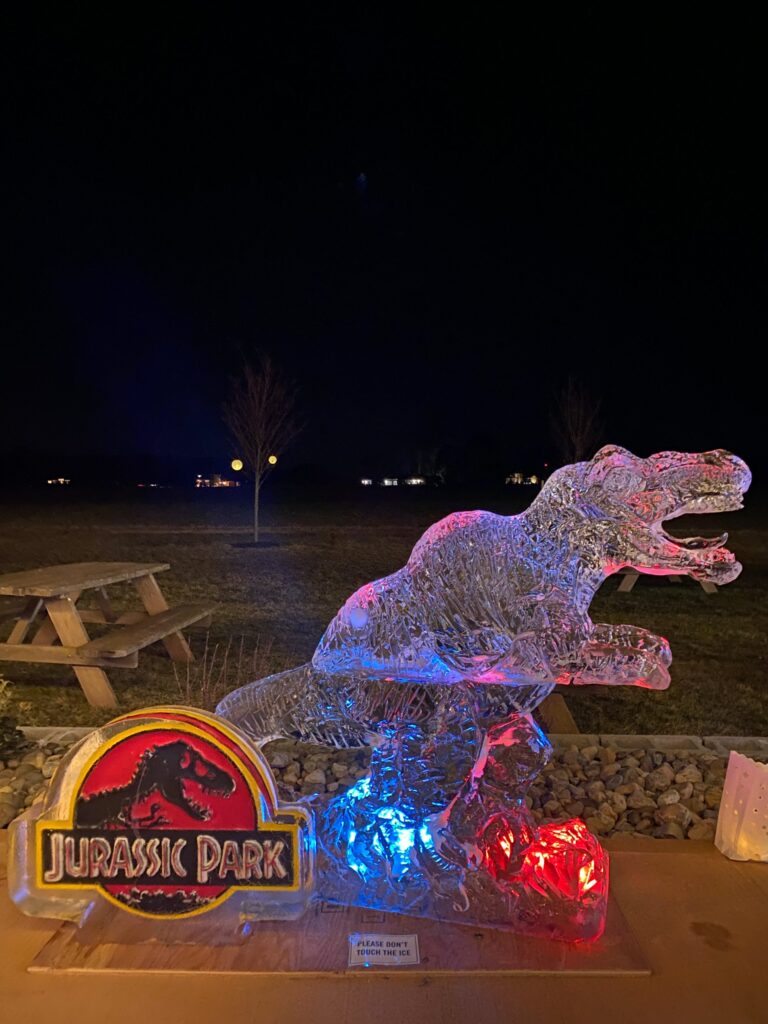a lit up statue of a dinosaur in a park