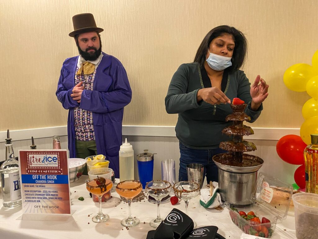 a man and a woman standing behind a table covered in food