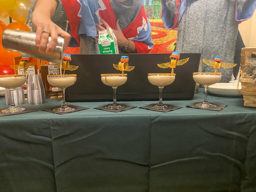 a man pouring drinks into glasses on top of a table