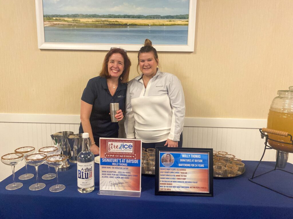 a couple of women standing next to each other at a table