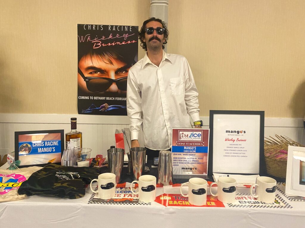 a man standing behind a table with a lot of items on it