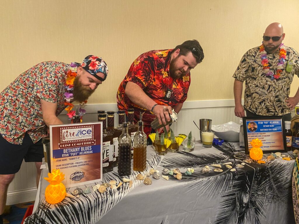 a group of men standing around a table covered in food