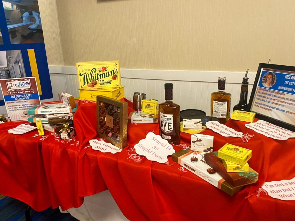 a table with a red table cloth covered with bottles of liquor