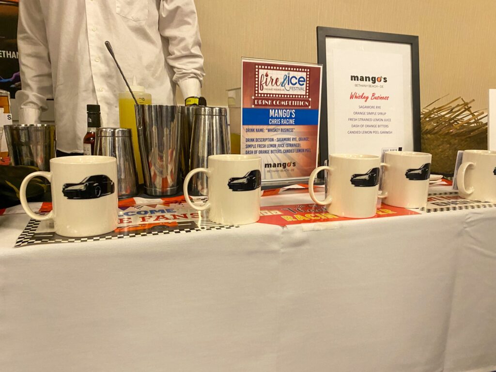 a table with coffee mugs and a sign on it