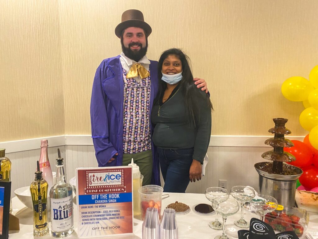 a man and woman standing in front of a table