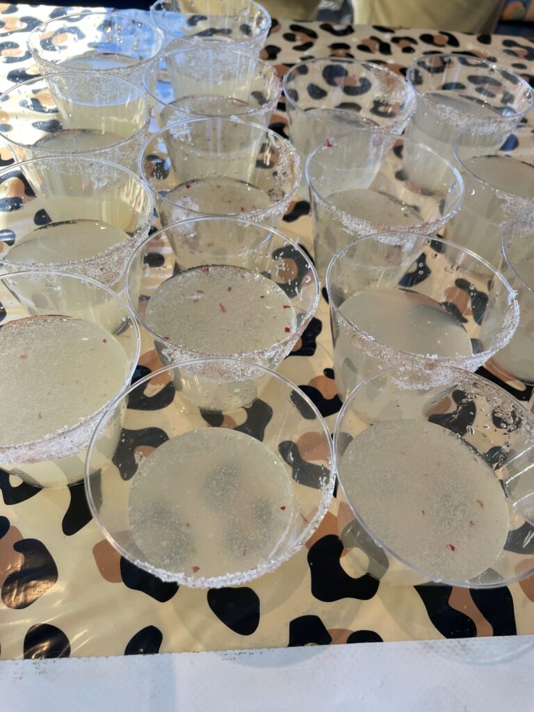 a table topped with lots of glasses filled with liquid