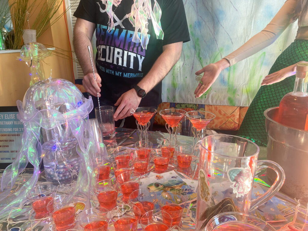 a man and a woman standing next to a table full of glasses