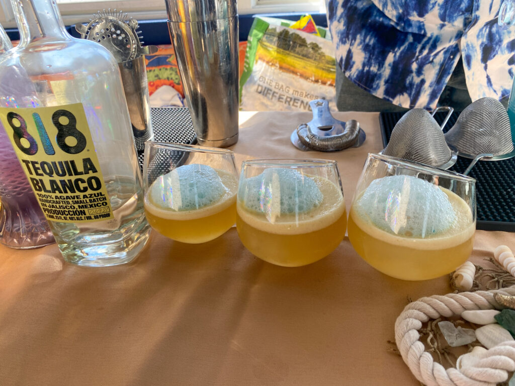 a table topped with three glasses filled with drinks