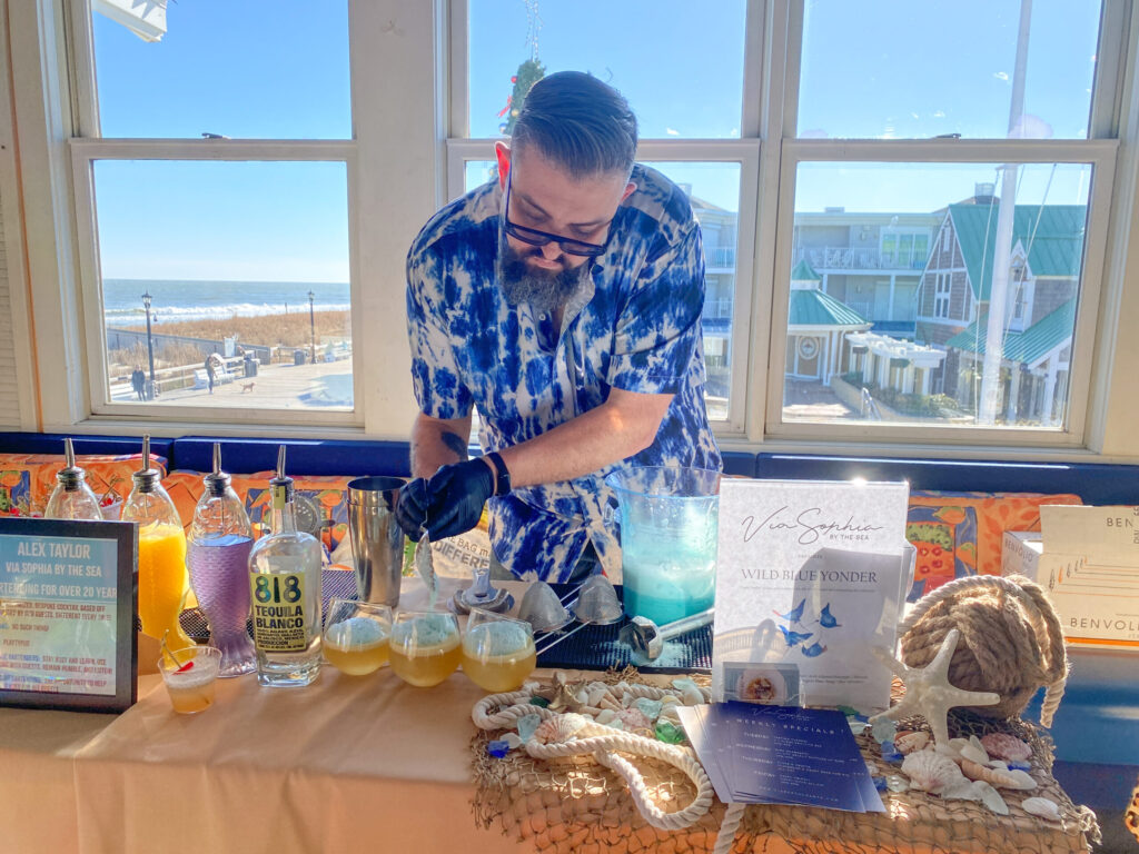 a man standing at a table filled with bottles of alcohol
