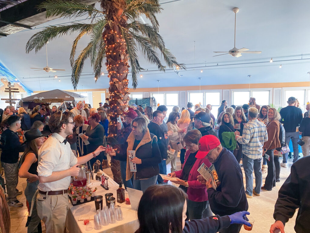 a large group of people standing around a bar