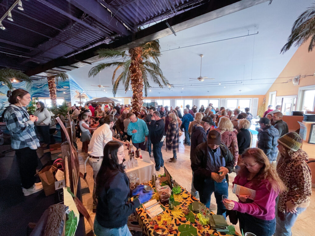 a group of people standing around a table filled with fruit