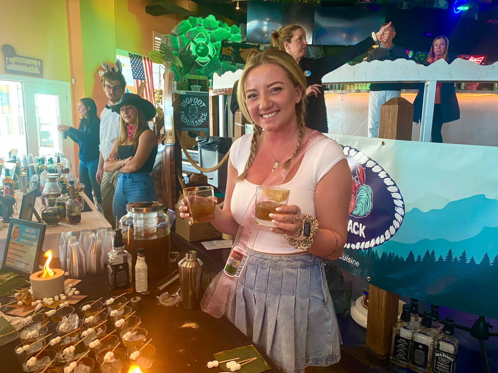 a woman standing at a bar holding a drink