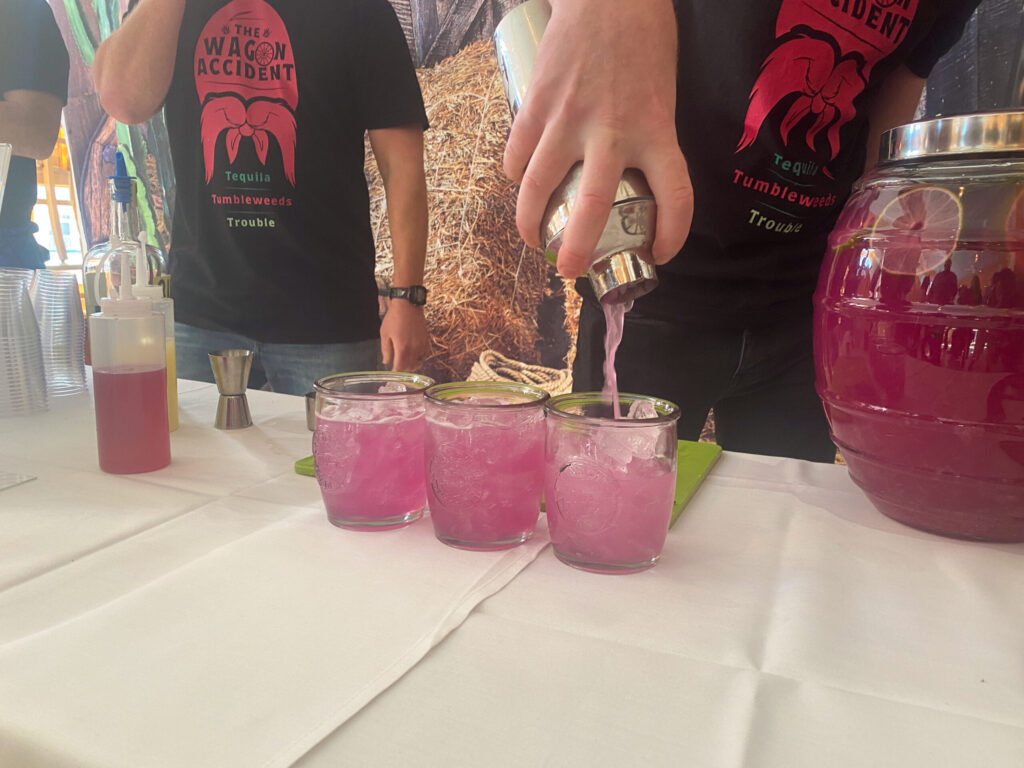 a group of people standing around a table with drinks