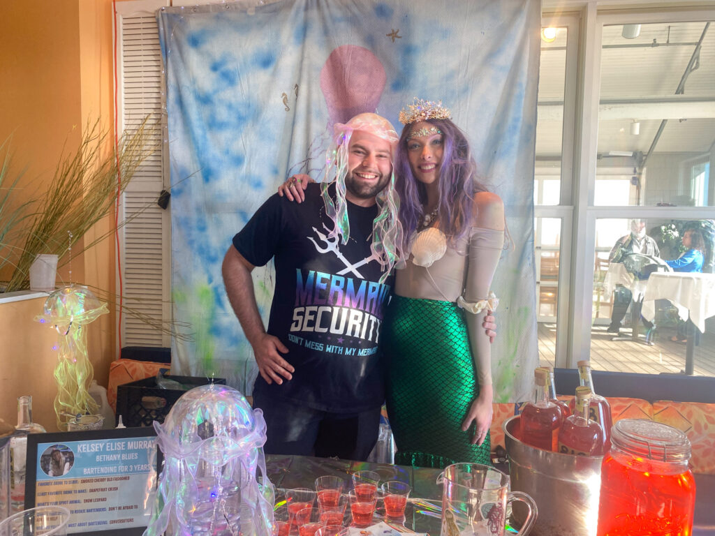 a man and a woman standing in front of a table