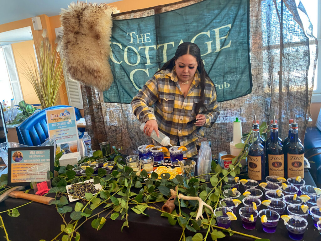 a woman standing in front of a table filled with plants