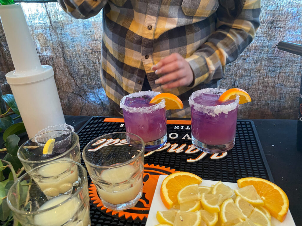 a man standing in front of a table filled with drinks
