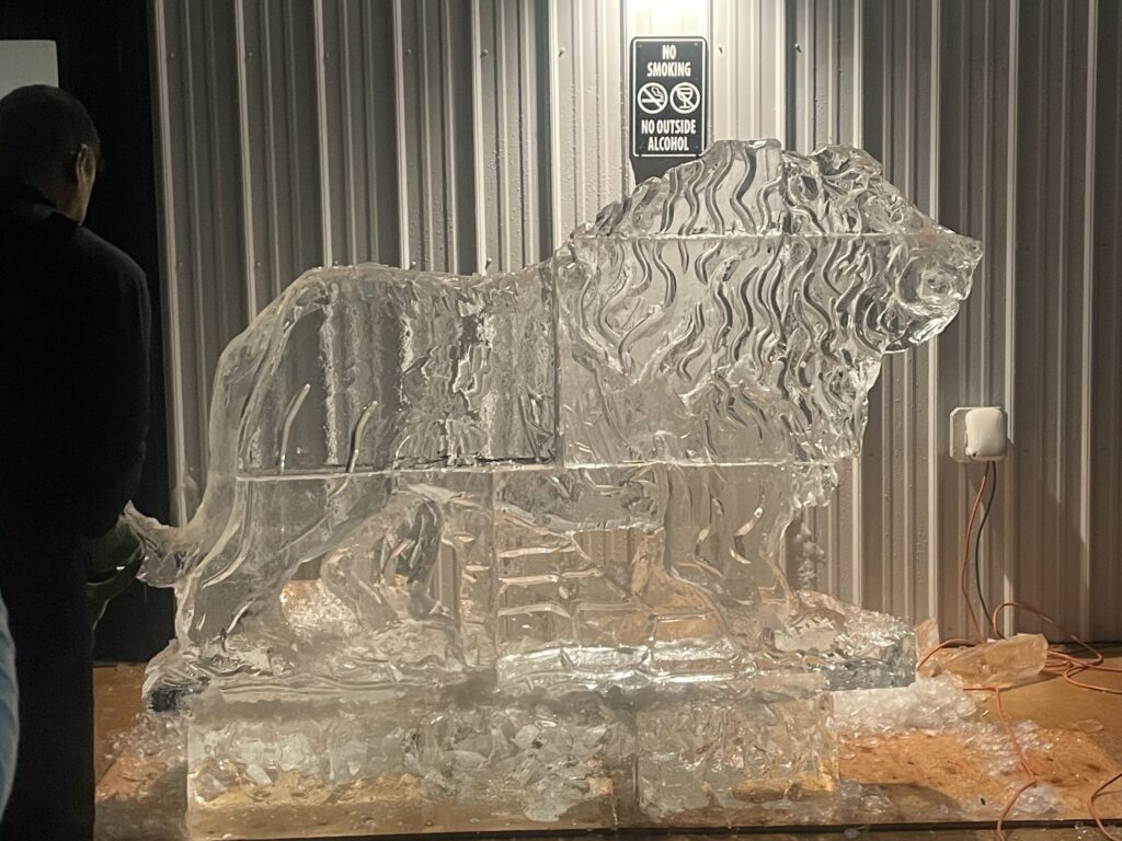a man standing next to an ice sculpture of a horse