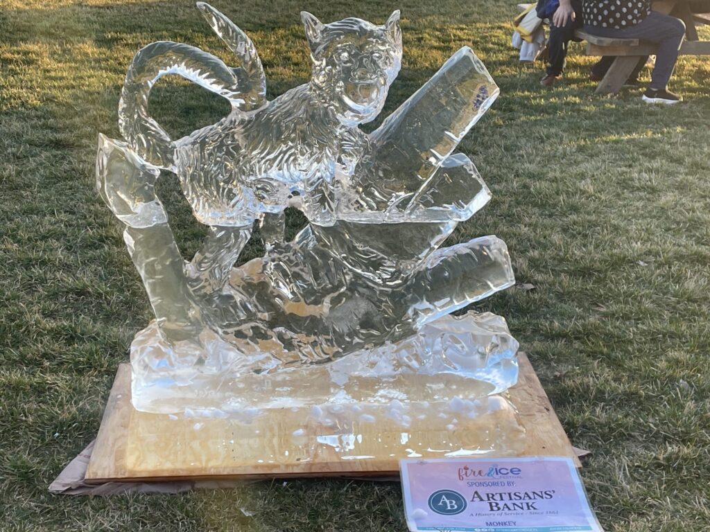 a glass sculpture of a cat on a rock