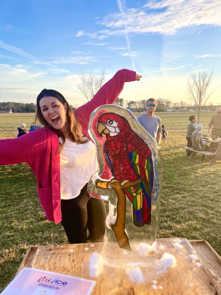 a woman standing in front of a sculpture of a parrot