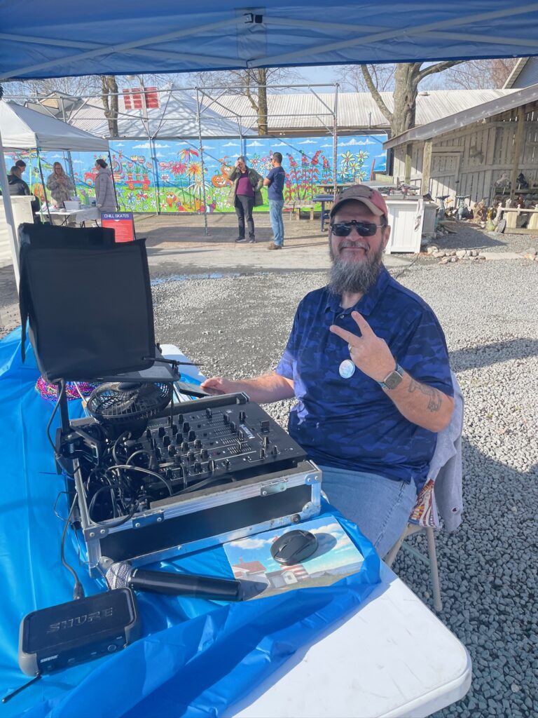 a man sitting at a table with a dj mixer