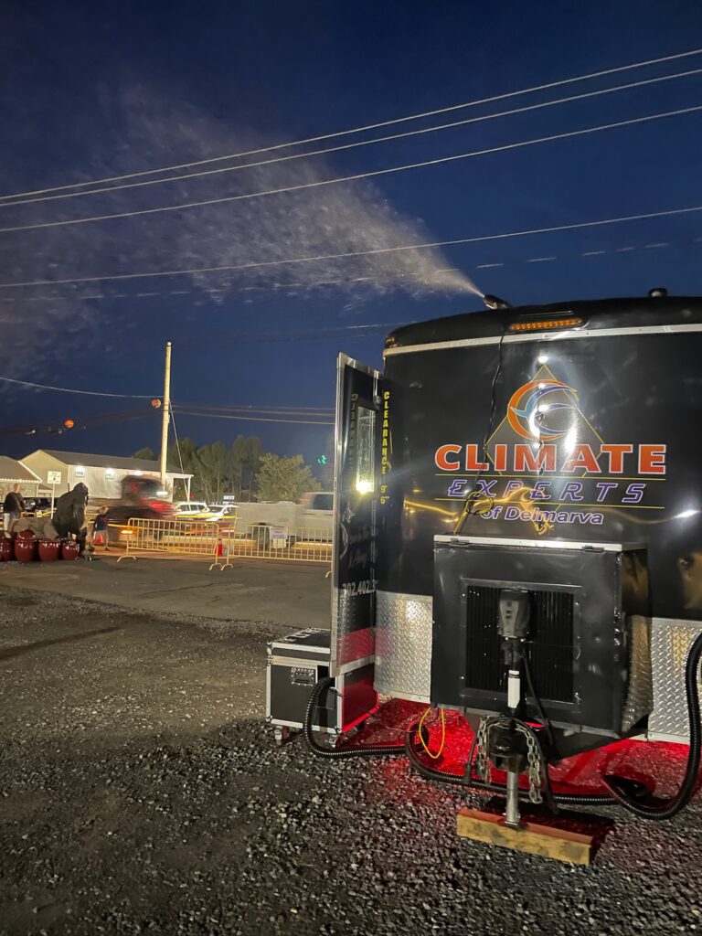 a black and red trailer parked on top of a gravel road