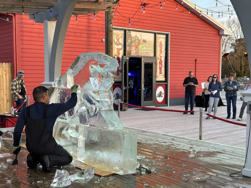 a man kneeling down next to an ice sculpture
