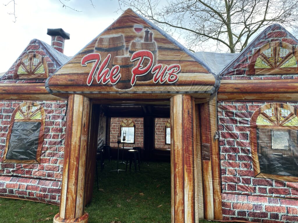 a building made out of wood with the word the pub painted on it