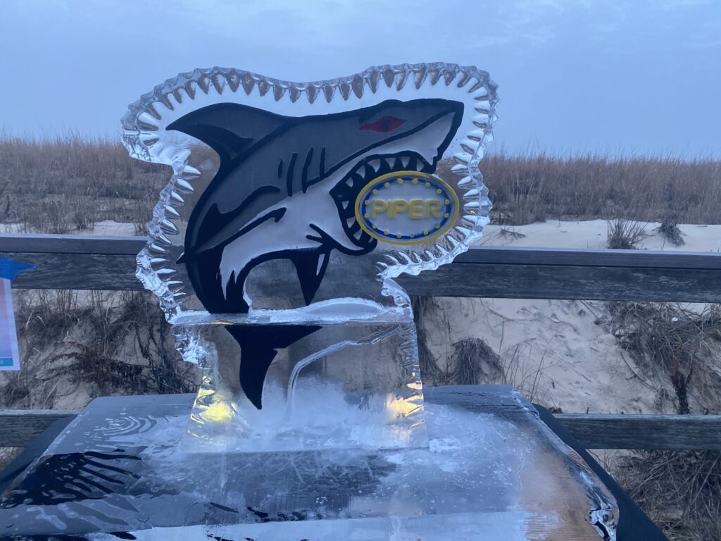 a glass trophy with a shark on it