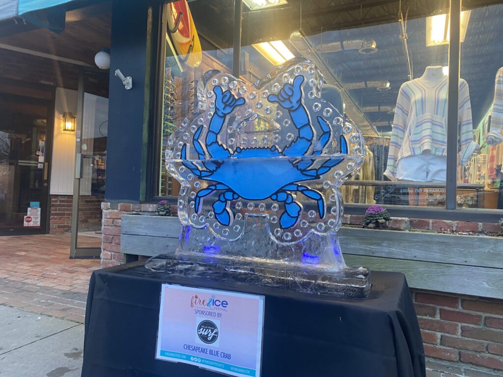 a glass sculpture of a blue crab in front of a store