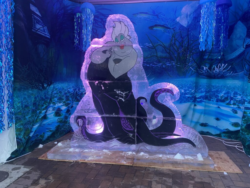 a large statue of a mermaid sitting on top of a wooden platform