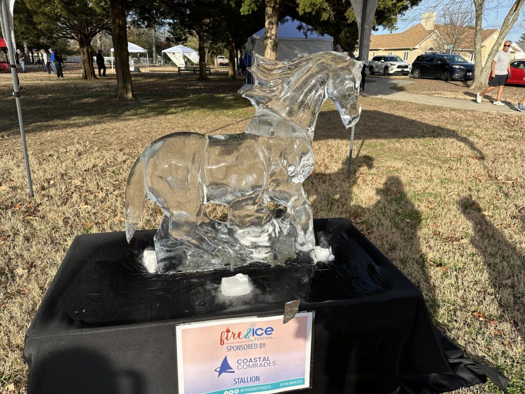 a glass horse on display in a park