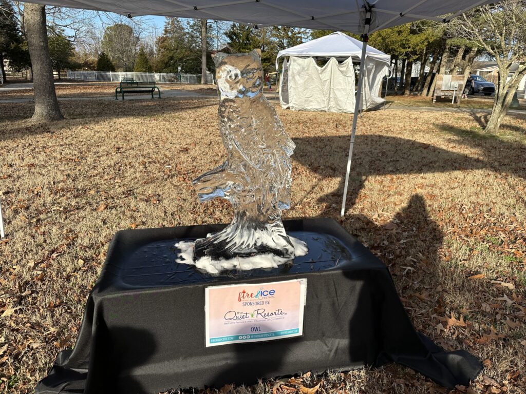 a statue of an owl on a table under a tent