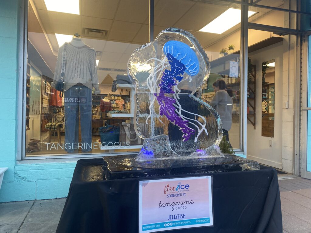 a glass sculpture of a woman is on display in front of a store
